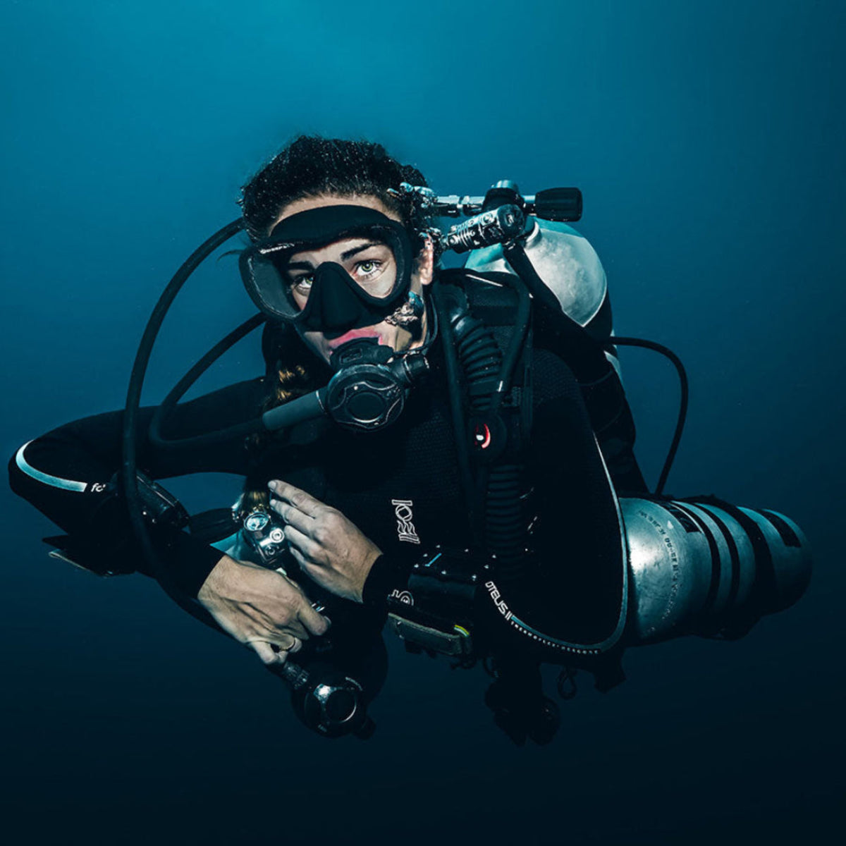 Person in scuba diving gear underwater with a blue background